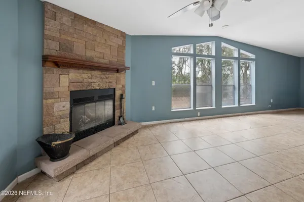 a view of an empty room with a fireplace and a window
