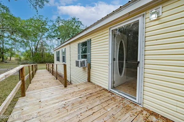 a view of a house with backyard and trees