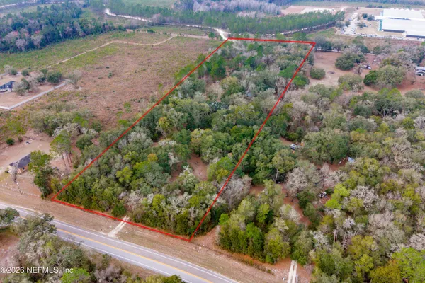 a view of a pathway both side of grassy field with shrub