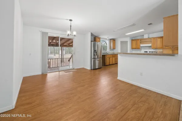 a view of a kitchen with wooden floor and a window