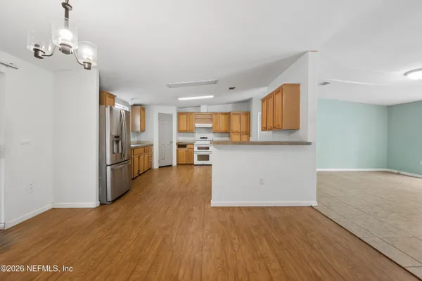 a view of a kitchen with wooden floor and electronic appliances