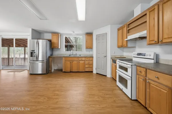 a kitchen with stainless steel appliances granite countertop a refrigerator and a stove top oven