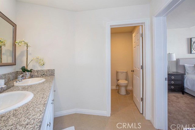 1523 East Windsor Road, Unit 209A Glendale, CA 91205 - Photo 17 of 29 a bathroom with a granite countertop sink and a mirror