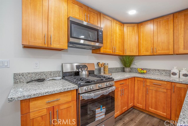 1523 East Windsor Road, Unit 209A Glendale, CA 91205 - Photo 7 of 29 a kitchen with stainless steel appliances granite countertop wooden cabinets a stove top oven