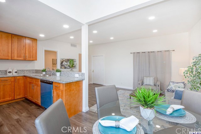 1523 East Windsor Road, Unit 209A Glendale, CA 91205 - Photo 9 of 29 a kitchen with stainless steel appliances granite countertop a refrigerator a stove a sink dishwasher and a dining table with wooden floor