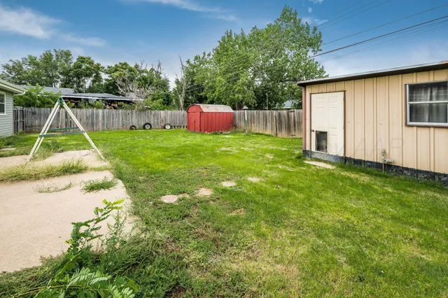 a view of a backyard with wooden fence