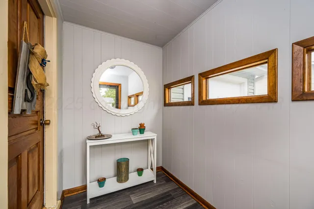 a hallway with front door wooden floor and windows