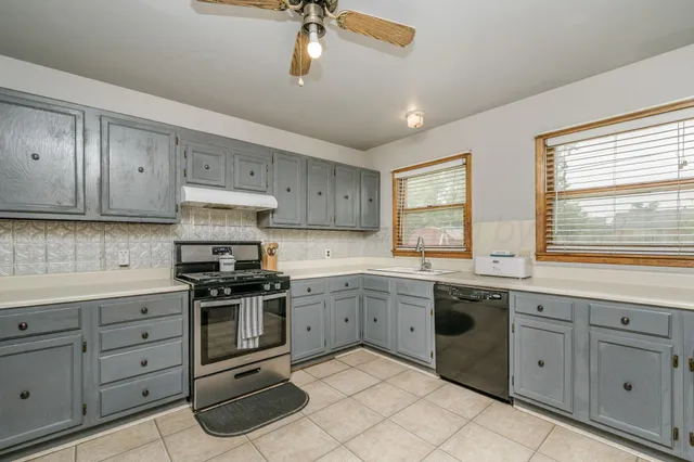 a kitchen with white cabinets and sink