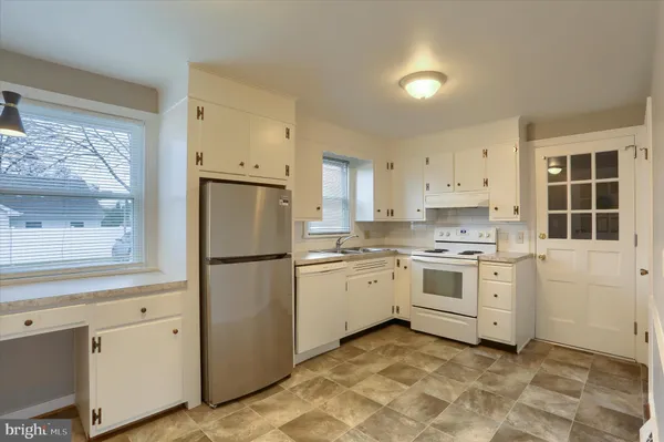 a kitchen with white cabinets and white appliances