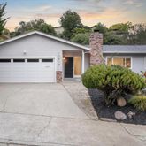 a view of a house with a yard and potted plants