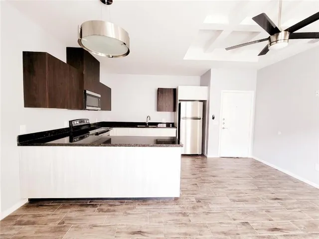 a view of kitchen with sink microwave and refrigerator
