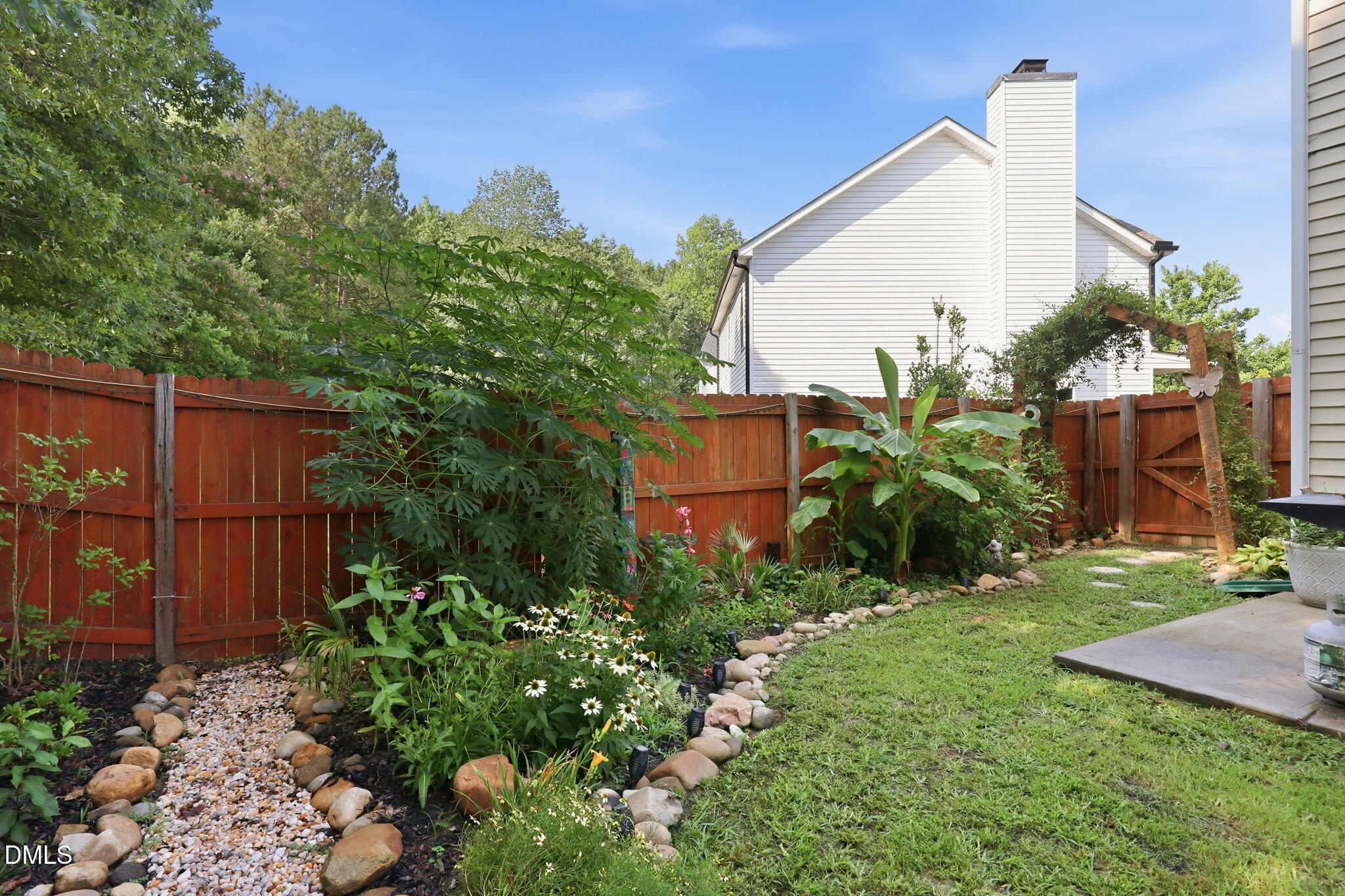 4232 Dalcross Road Raleigh, NC 27610 - Photo 36 of 42 a view of a garden with a building in the background