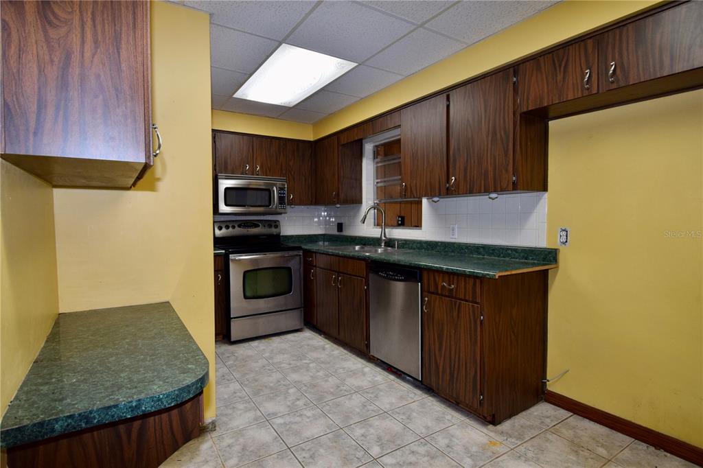 1508 Lake Mills Road Chuluota, FL 32766 - Photo 25 of 37 a kitchen with stainless steel appliances granite countertop a stove a sink and a microwave