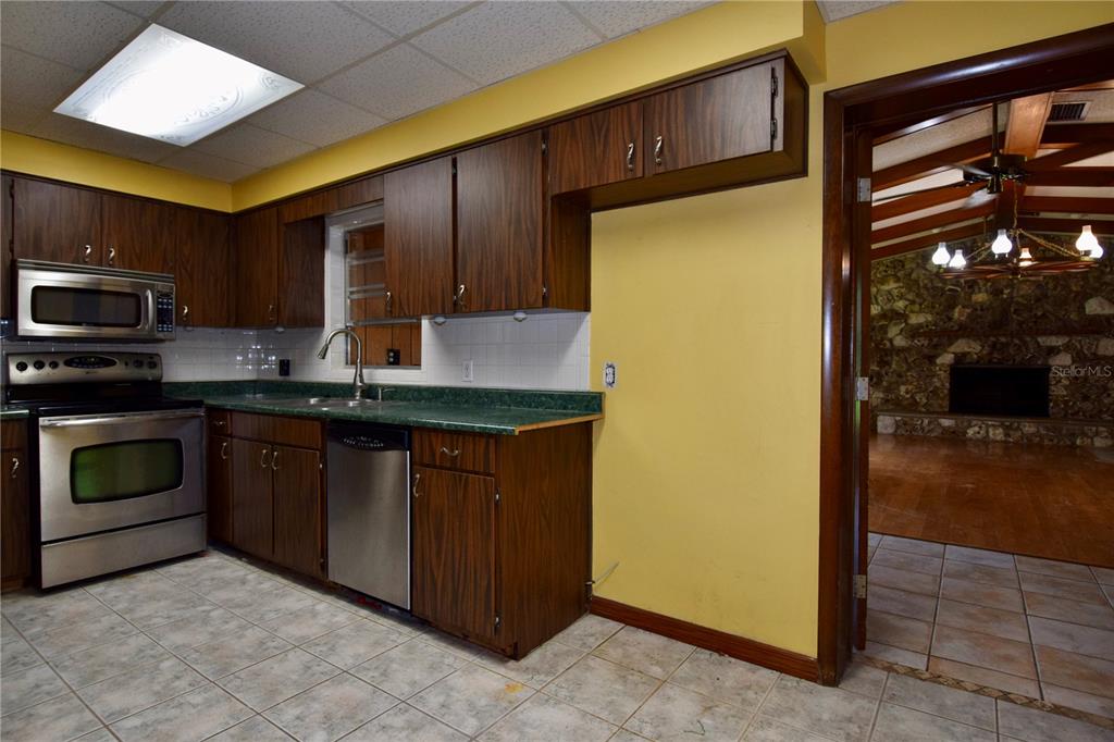 1508 Lake Mills Road Chuluota, FL 32766 - Photo 26 of 37 a kitchen with stainless steel appliances granite countertop a stove a sink and a refrigerator