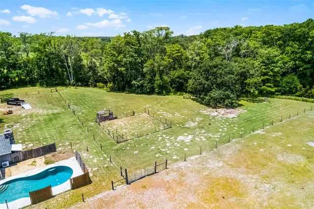 a view of a backyard with swimming pool and deck