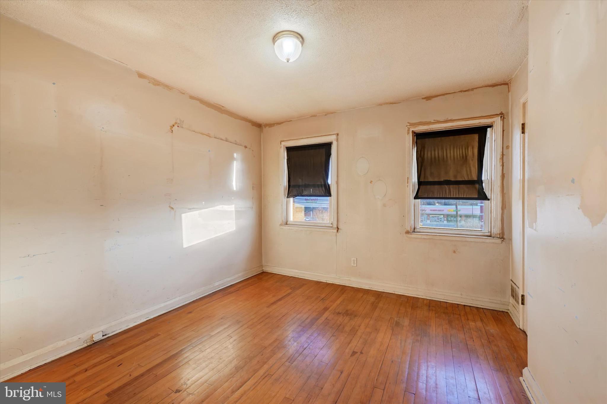 414 Kane Street Baltimore, MD 21224 - Photo 11 of 15 an empty room with wooden floor and windows