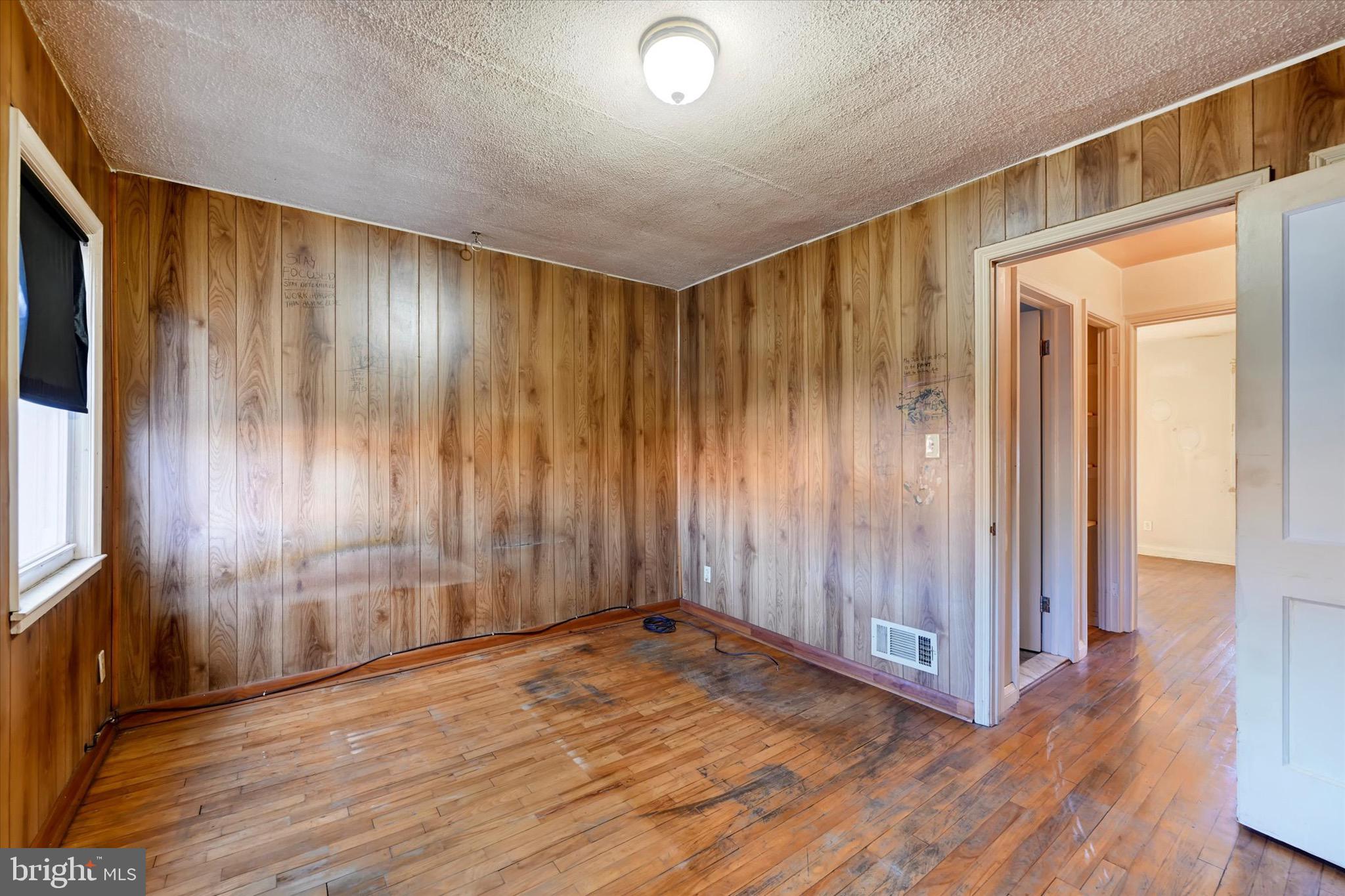 414 Kane Street Baltimore, MD 21224 - Photo 12 of 15 a view of an empty room with wooden floor and a window