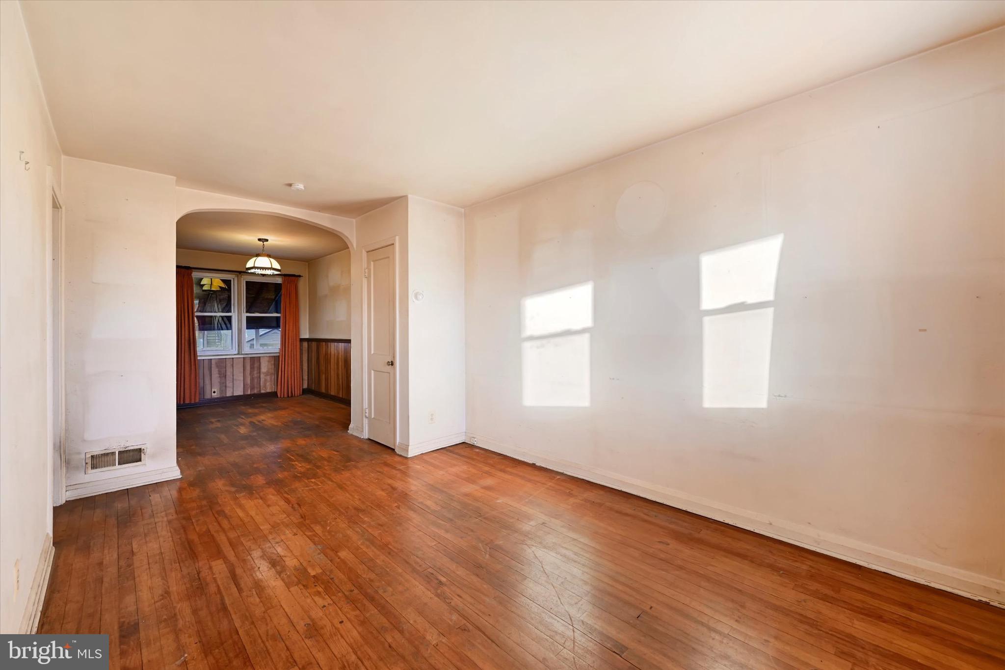 414 Kane Street Baltimore, MD 21224 - Photo 7 of 15 an empty room with wooden floor and windows