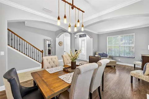 a kitchen with stainless steel appliances granite countertop a sink a stove and a dining table with wooden floor