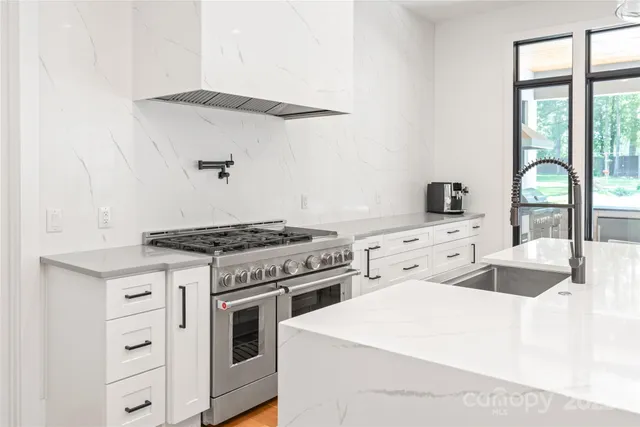 a kitchen with granite countertop a stove and a sink