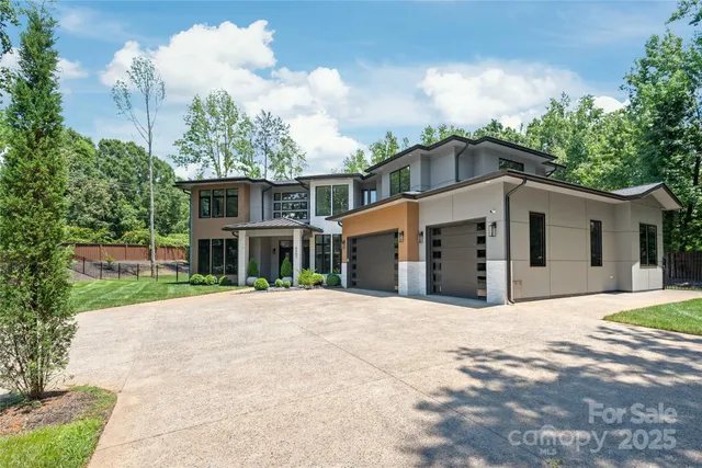 a front view of a house with a yard and potted plants