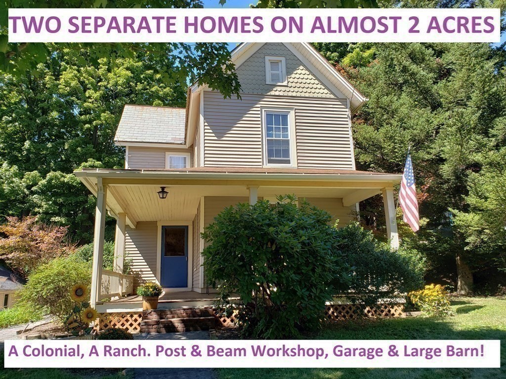 a view of a house with a small yard and large tree