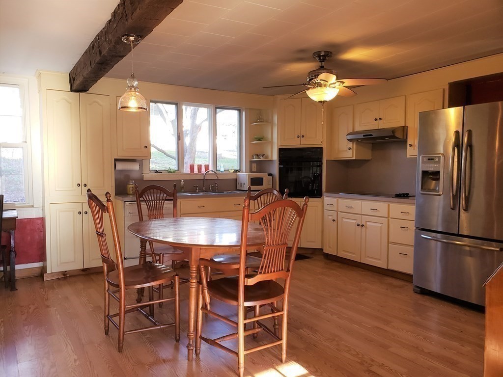 4 Pleasant Street Huntington, MA 01050 - Photo 26 of 38 a kitchen with stainless steel appliances a dining table chairs refrigerator and sink