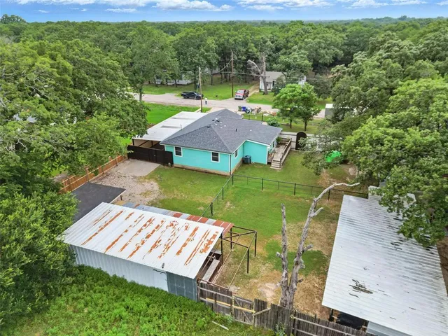 an aerial view of a house with a yard basket ball court and outdoor seating