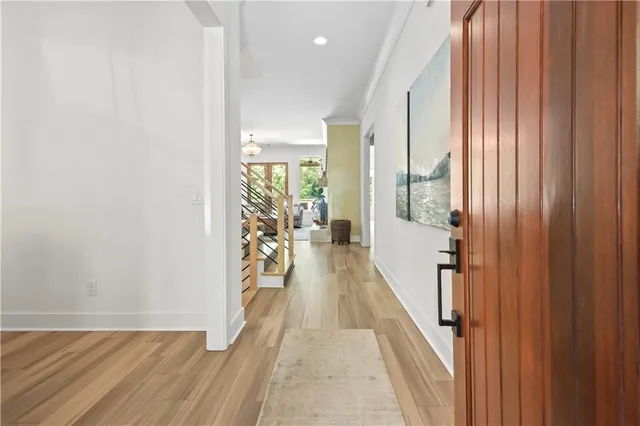 a view of a hallway with wooden floor and staircase
