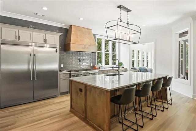 a kitchen with stainless steel appliances granite countertop a sink a stove a refrigerator and island