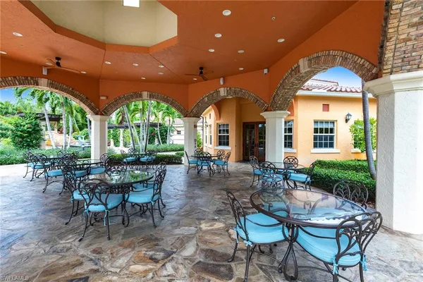 a view of a patio with table and chairs potted plants and a large tree