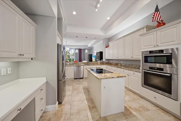a kitchen with stainless steel appliances granite countertop a refrigerator stove and sink