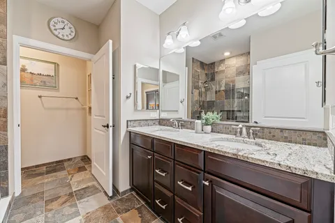 a spacious bathroom with a granite countertop sink and a mirror