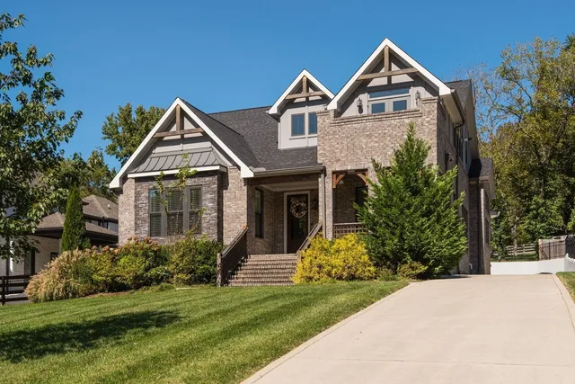 a front view of a house with a yard and trees