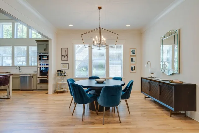 a dining room with furniture a chandelier and wooden floor