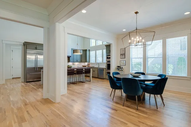 a dining room with furniture a chandelier and wooden floor