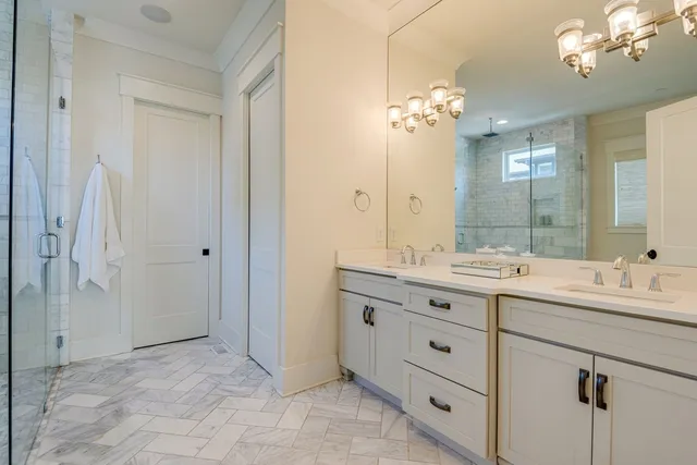 a bathroom with a double vanity sink mirror and shower