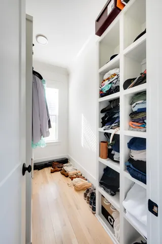 a view of walk in closet with clothes and shoes