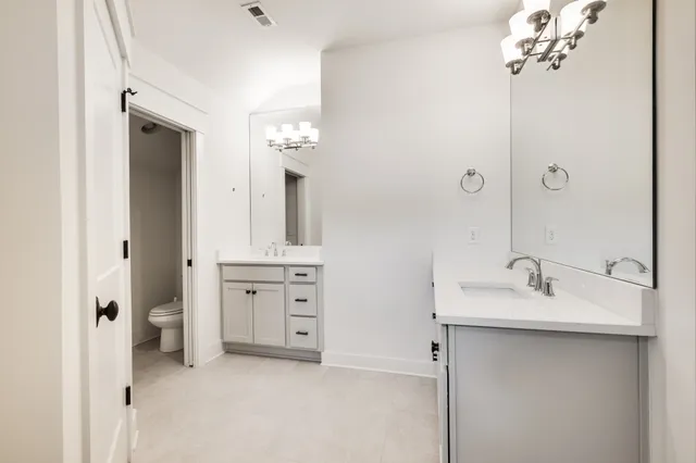 a spacious bathroom with a double vanity sink mirror and a bathtub