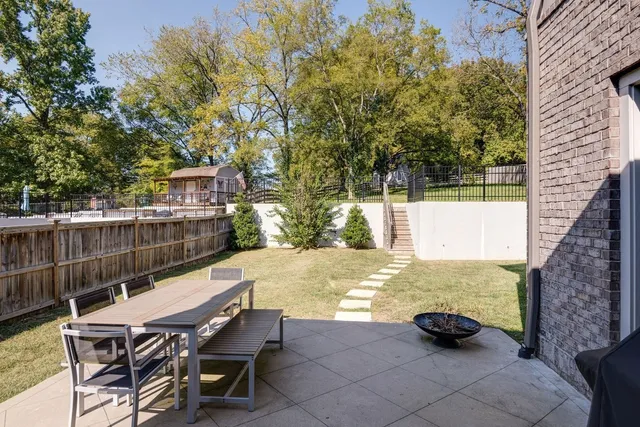 a view of a backyard with swimming pool and sitting area
