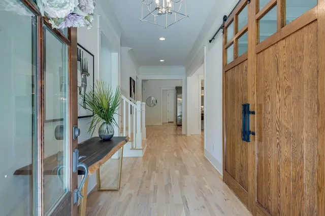 a view of a hallway with wooden floor and staircase