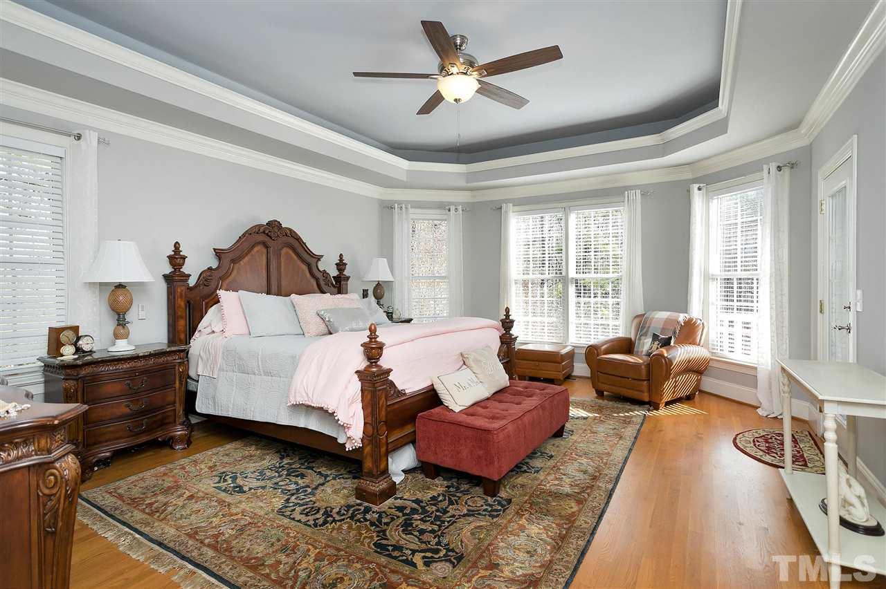 2521 Hunters Meadow Lane Raleigh, NC 27606 - Photo 5 of 30 a spacious bedroom with a bed a couch and a window