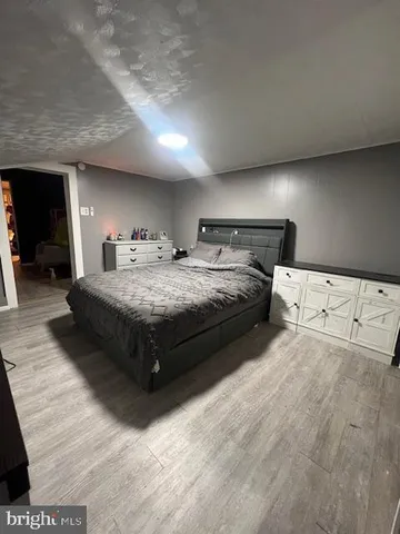 a spacious bedroom with a bed lamp and a fireplace