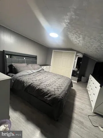 a bedroom with a bed a couch and a view of living room