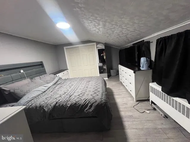 a bedroom with bed and wooden floor