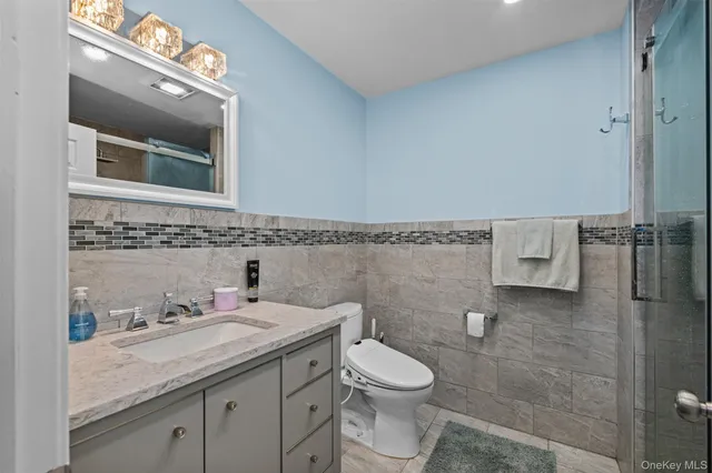a bathroom with a granite countertop sink a toilet and a mirror