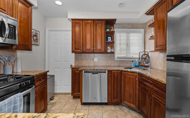 a kitchen with stainless steel appliances granite countertop a stove a sink and a microwave