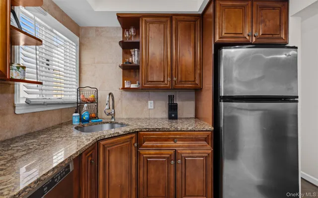 a kitchen with stainless steel appliances granite countertop a refrigerator and a sink