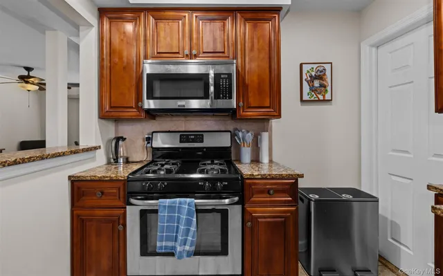 a kitchen with stainless steel appliances granite countertop a stove and a microwave