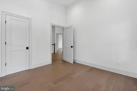 an empty room with wooden floor and entrance